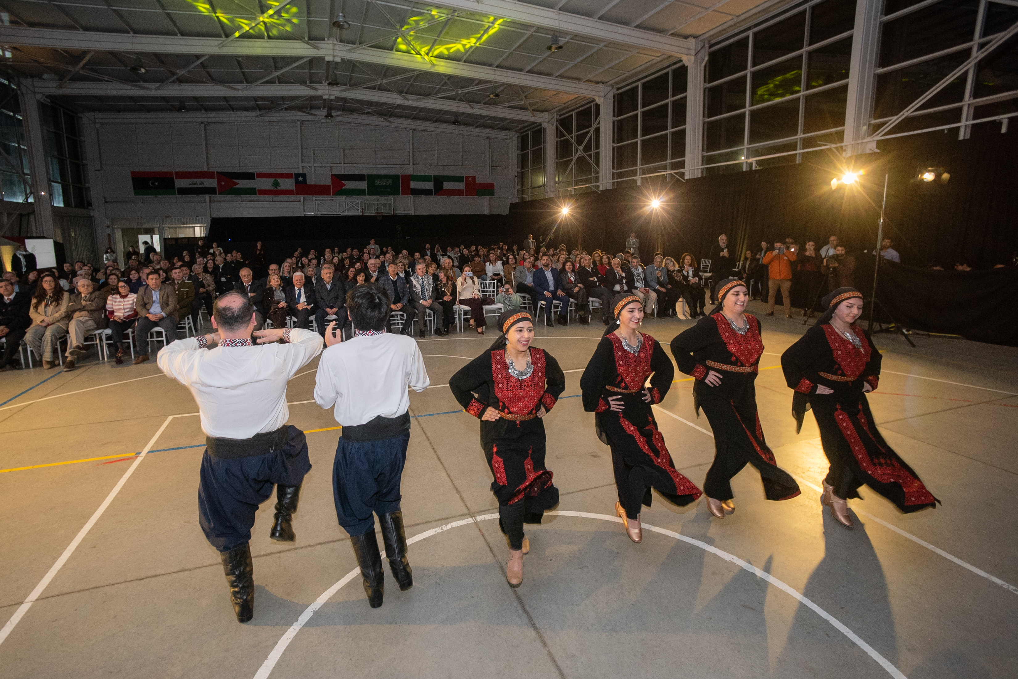 Grupo de bailarines presenta una danza árabe ante el público reunido en la ceremonia.