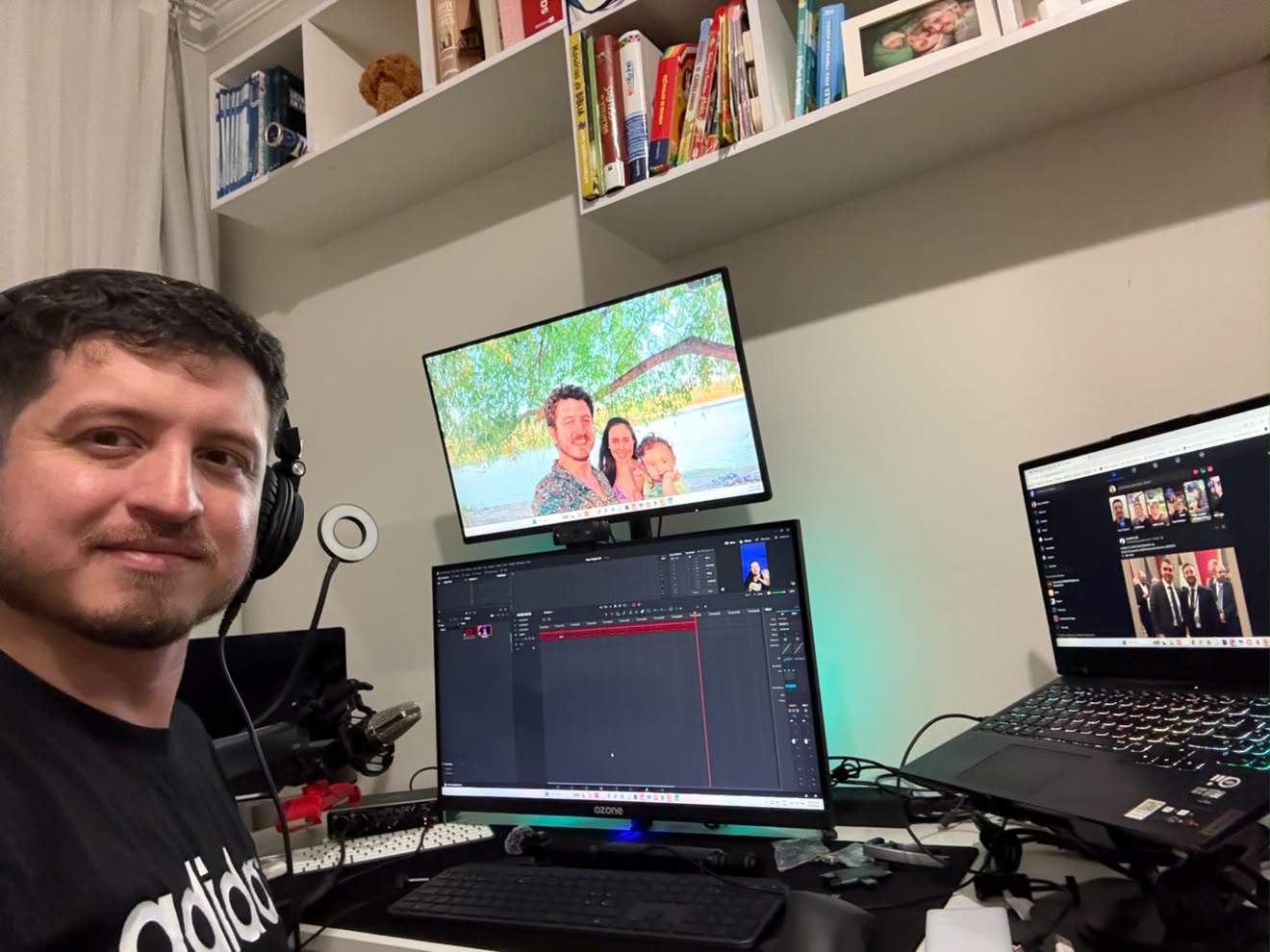 Mario Medina con audífonos y un micrófono, frente a un escritorio con tres pantallas y una interfaz de edición de video.