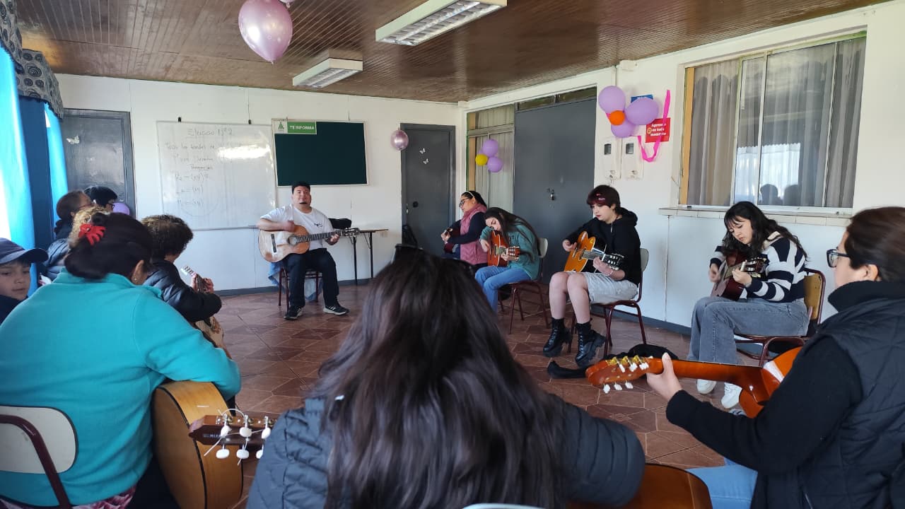 Participantes de distintas edades practican guitarra en un taller de Pepe Flores.