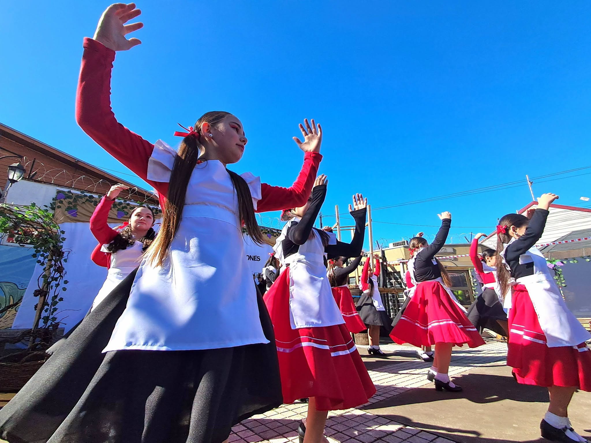 Integrantes de Danzares bailan con vestuario folclórico durante la intervención de la Escuela NNS.